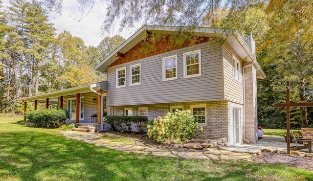 Secluded home on 6 acres with stocked pond, dock, outdoor kitchen, & fireplaces